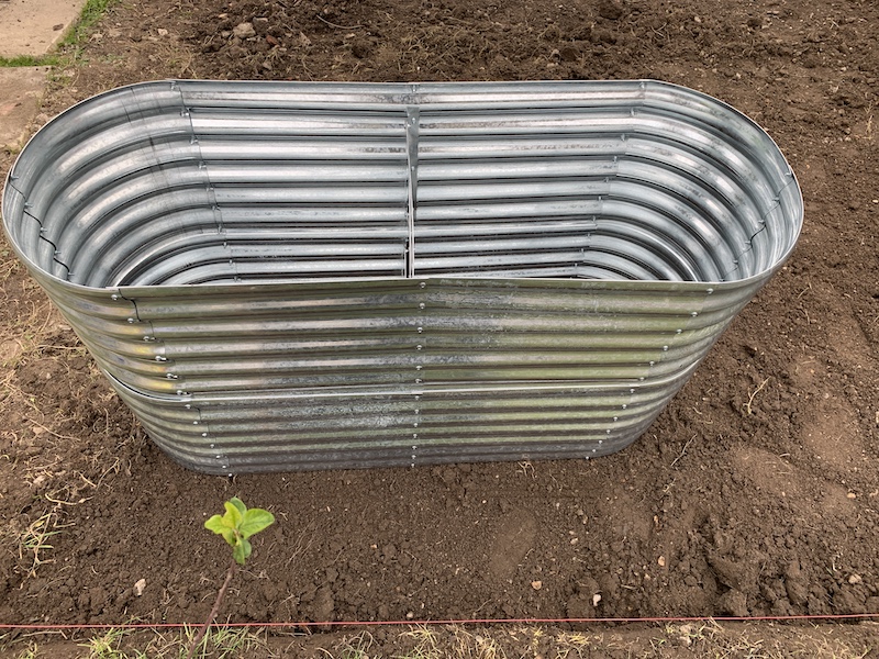 Side view of a metal raised garden bed.
